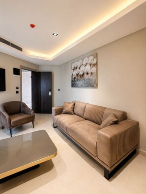 A modern living room with a sofa, armchair, and a coffee table.