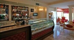 Eine Bar mit Regalen voller Flaschen, einem Fernseher und einer Vitrine mit Lebensmitteln.
