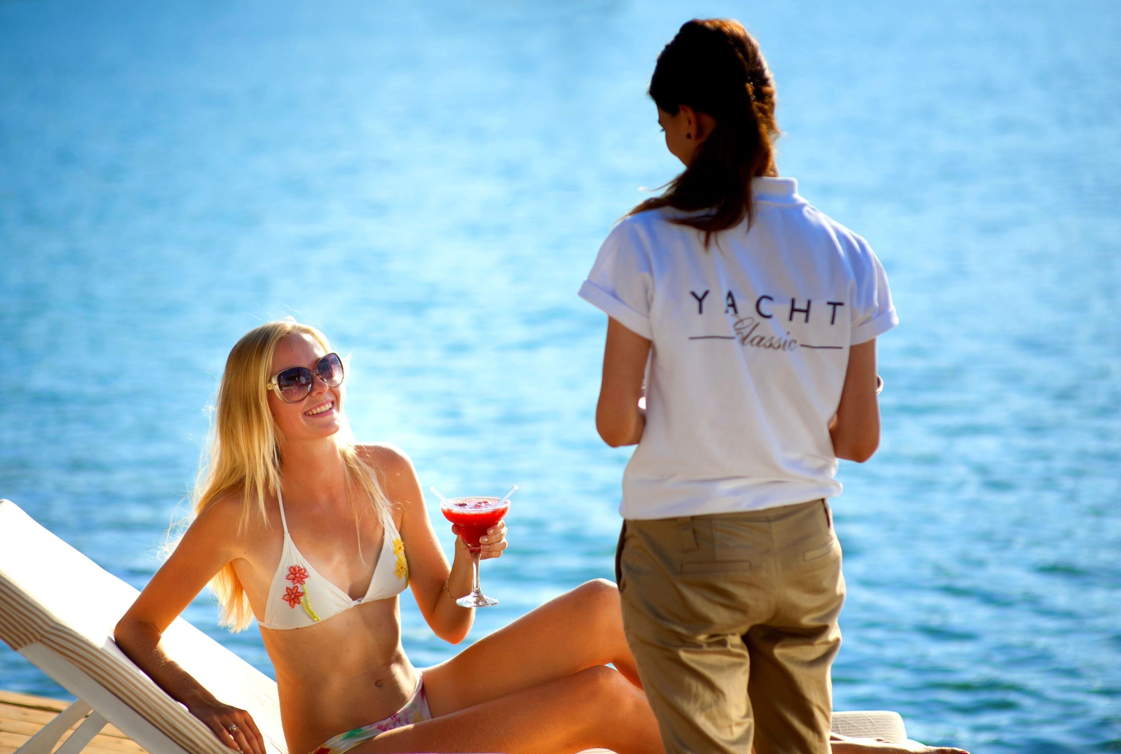 Zwei Personen an einem Pool mit freiem Blick auf das Wasser.