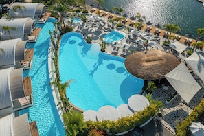 Ein Resort mit einem großen Swimmingpool, Strandhütten und einem Strandbereich.