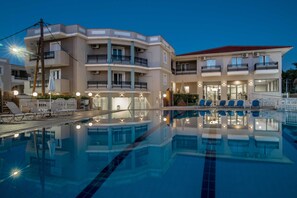 Una piscina al aire libre, sillones reclinables de piscina