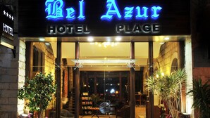Exterior del hotel Bel Azur y Plage, con entrada despejada, plantas en macetas y un área de estar visible en el interior.