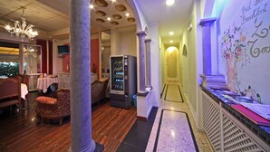 A hotel lobby with a dining area, a vending machine, and a reception desk. - Bed and Breakfast La Terrazza (Brescia)