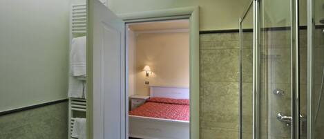 A bathroom with a toilet, bidet, and shower.