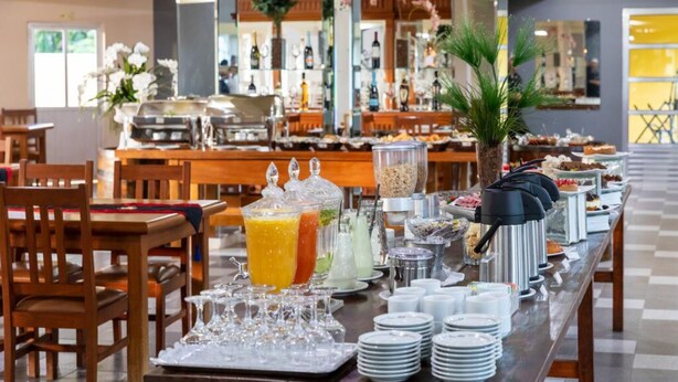 A buffet setup with various food stations, a coffee station, and a juice bar. - Canzi Cataratas Hotel (Foz do Iguacu)