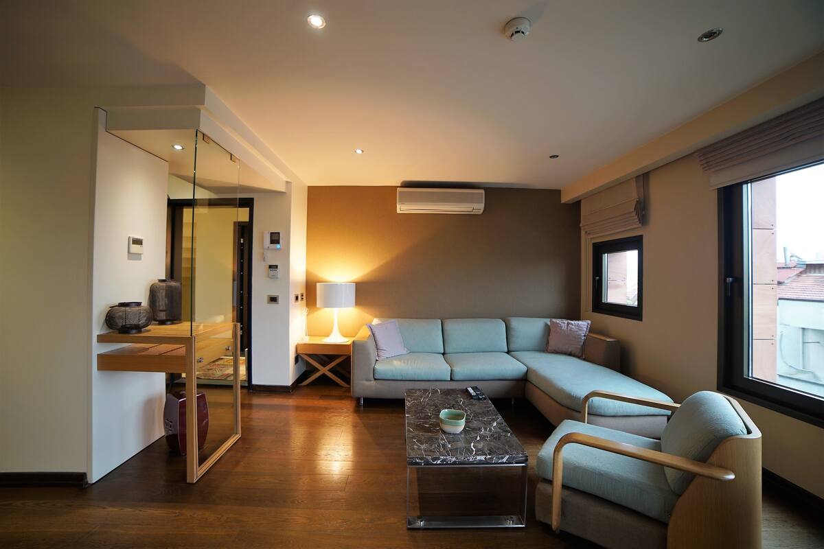 Una sala de estar moderna con un sofá, una mesa de centro y un separador de vidrio.