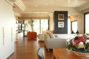 A modern living room with a dining area, a sofa, and a coffee table.