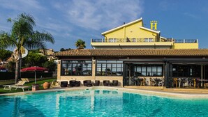 Un hotel con piscina, zona de estar al aire libre y bar.