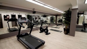 Un gimnasio moderno con cintas de correr, bicicletas estáticas y máquinas de pesas.