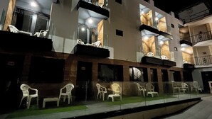 A multi-story building with outdoor seating and a glass railing. - New "Villa Albero" Boutique (Torremolinos)