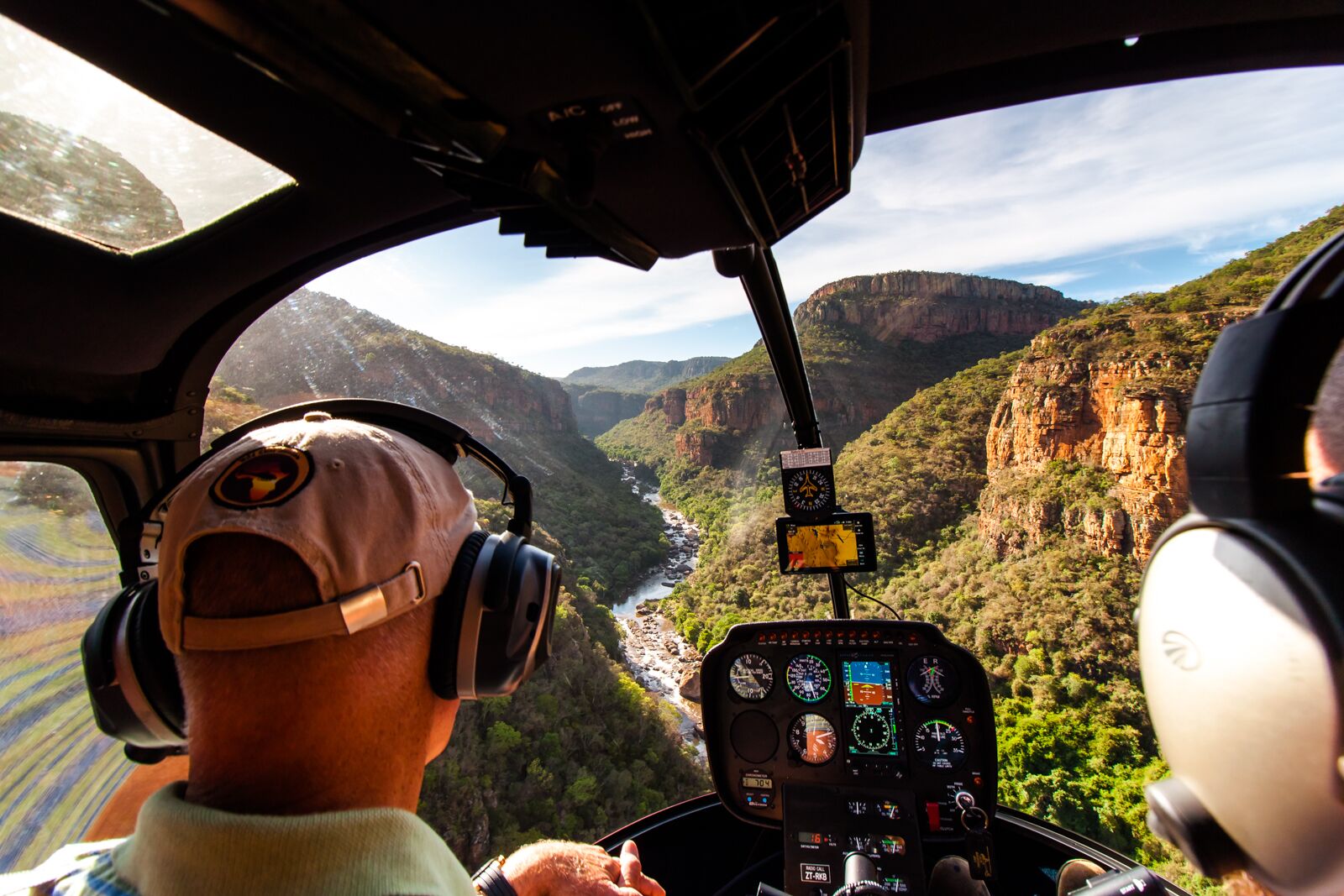 A helicopter cockpit with a view of a canyon.