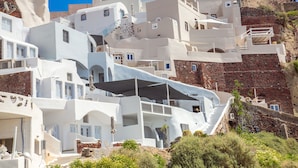 A white building with a staircase and a view of a mountain.