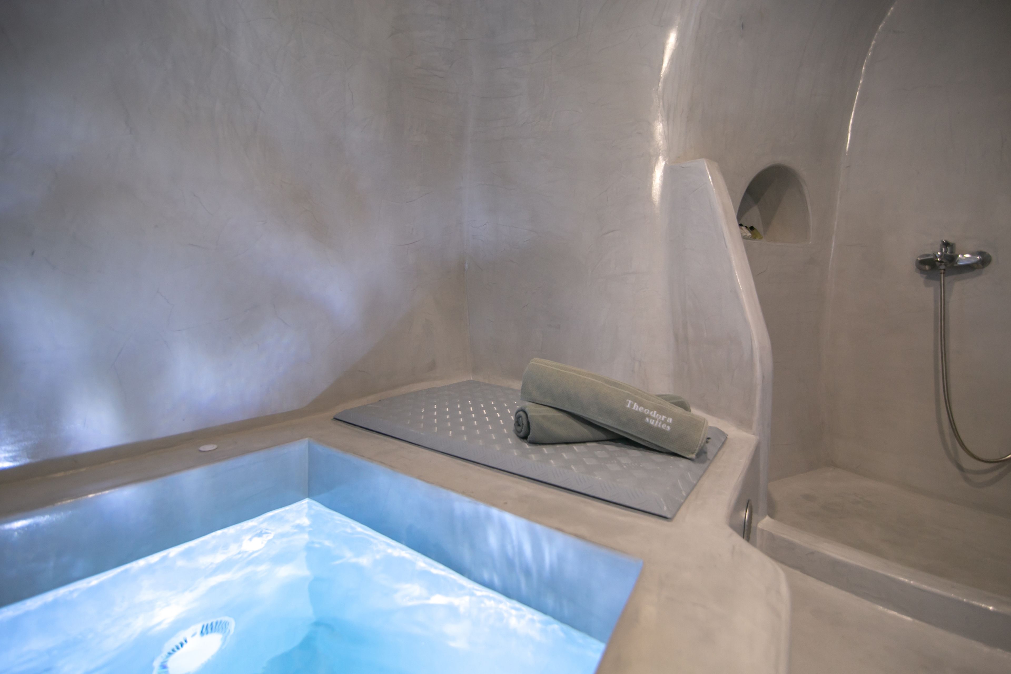 A modern bathroom with a built-in bathtub, a shower area, and a small alcove.
