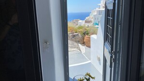 A view from a window with a view of white buildings and the sea.