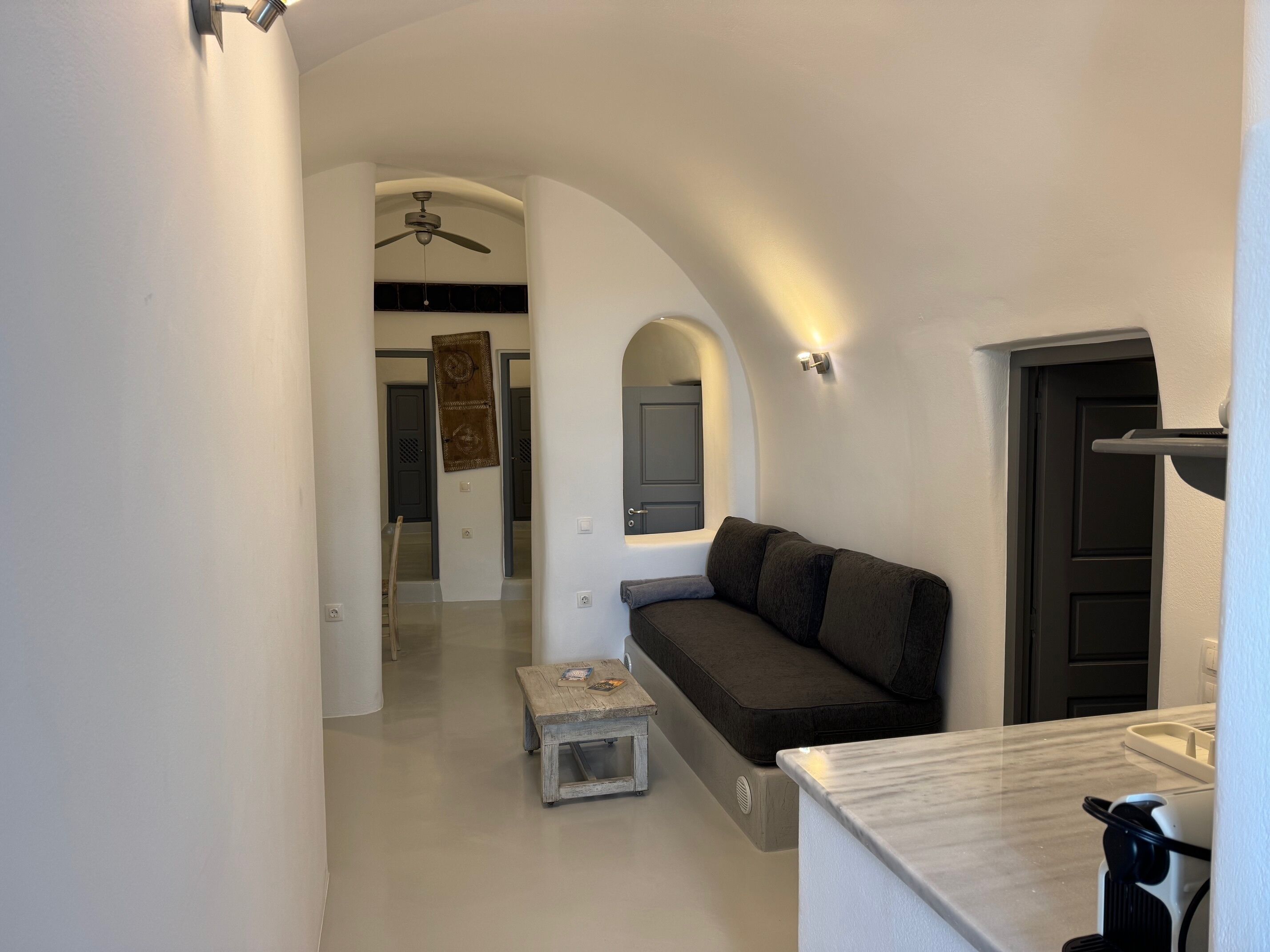 Um interior moderno com um sofá, uma mesinha e um ventilador de teto.