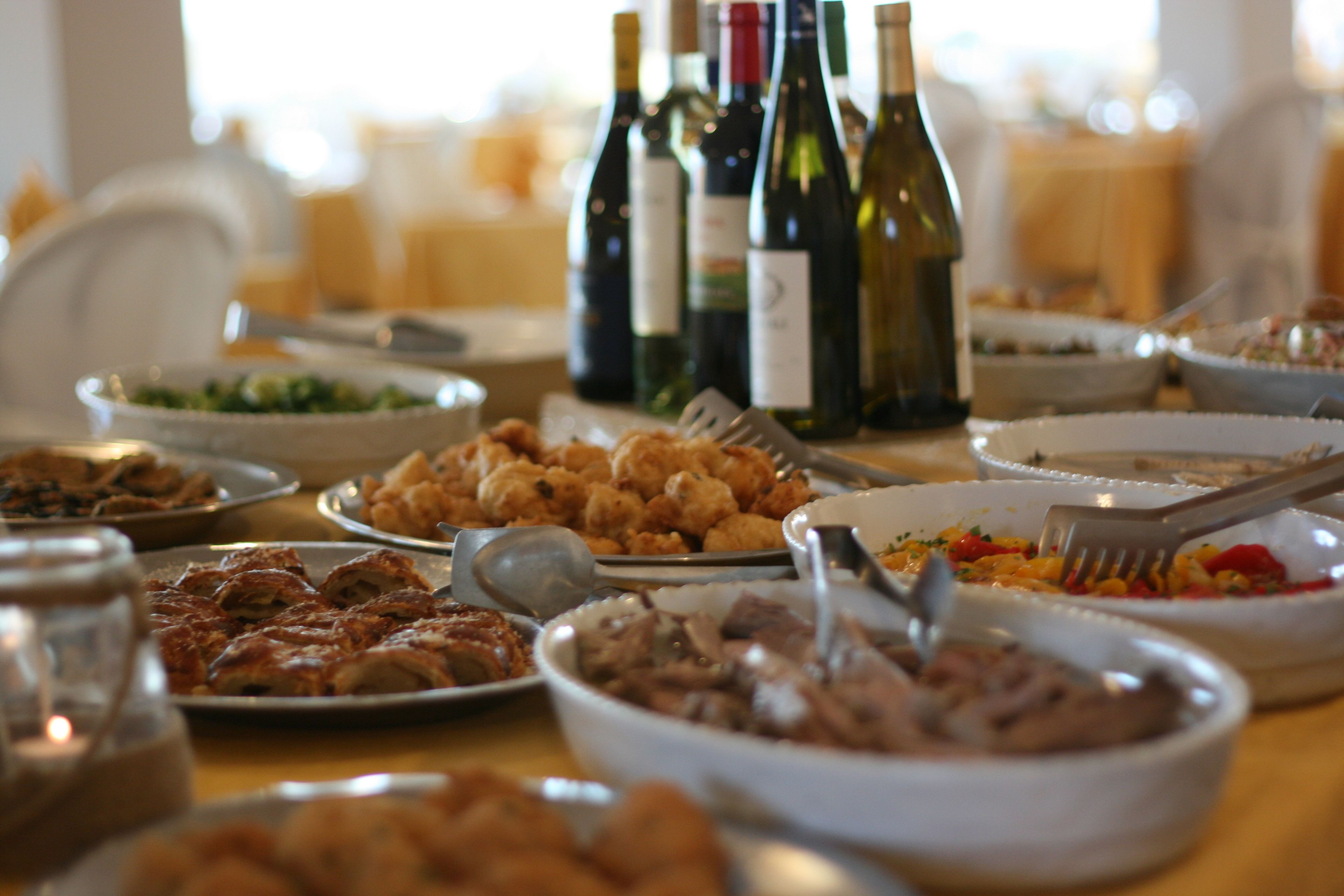 Una mesa de buffet con diversos platos y botellas de vino.