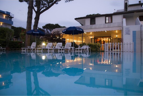 Piscine extérieure en saison, parasols, chaises longues