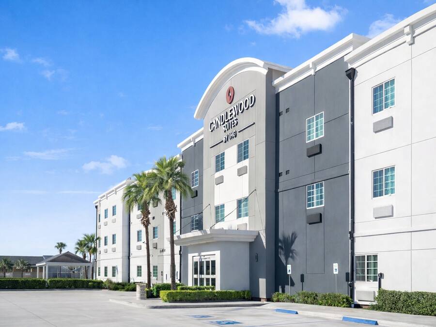Een modern hotel met een opvallend bord waarop staat 'Candlewood Suites by IHG'.