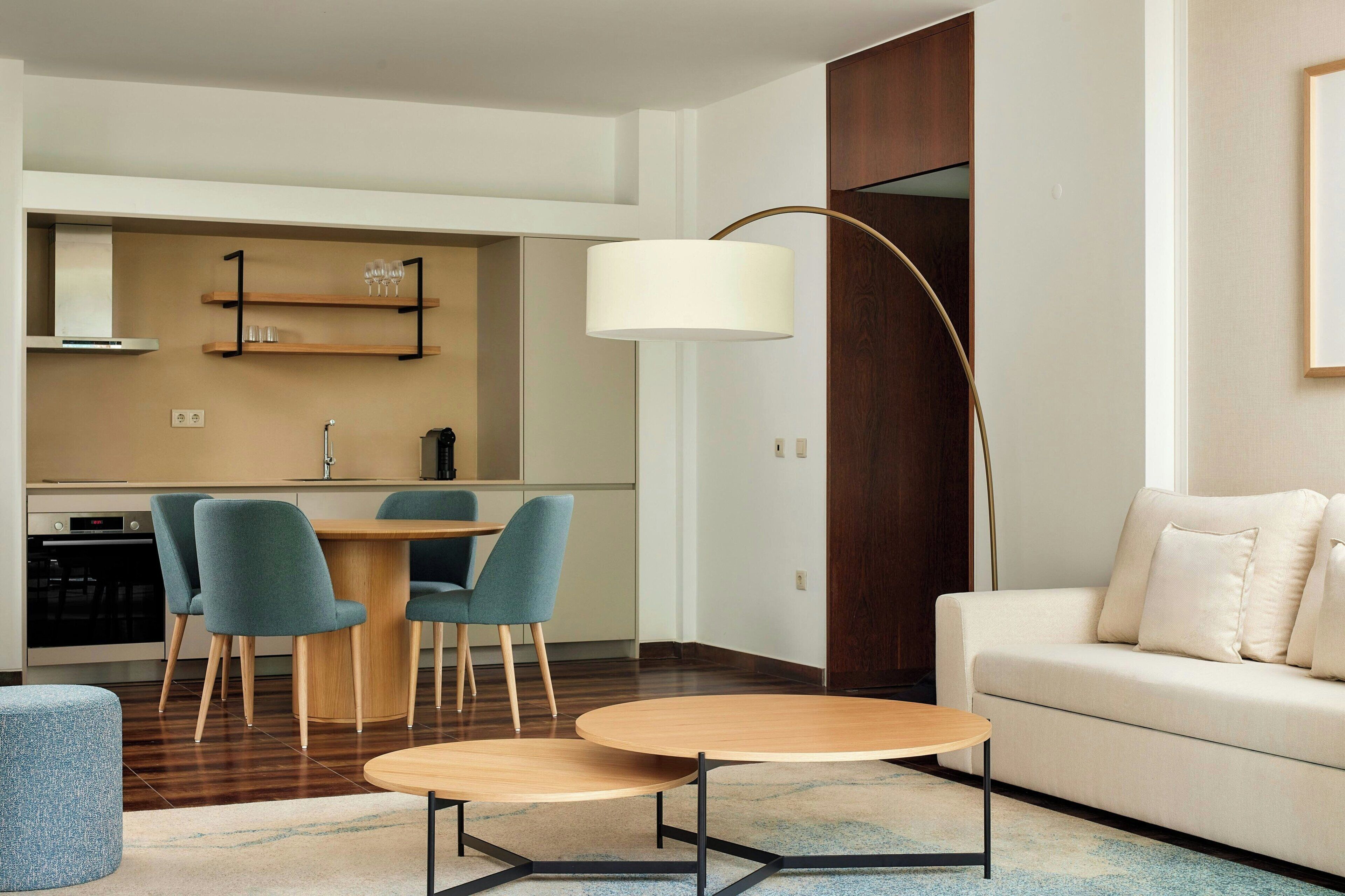 Een moderne woonkamer met een bank, een salontafel, en een eethoek met stoelen en een tafel.