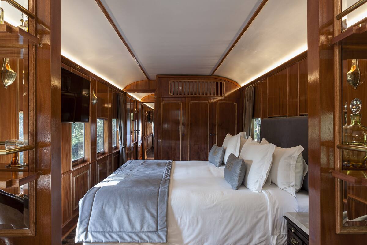 Une chambre à coucher avec un grand lit, des lambris en bois et une fenêtre.
