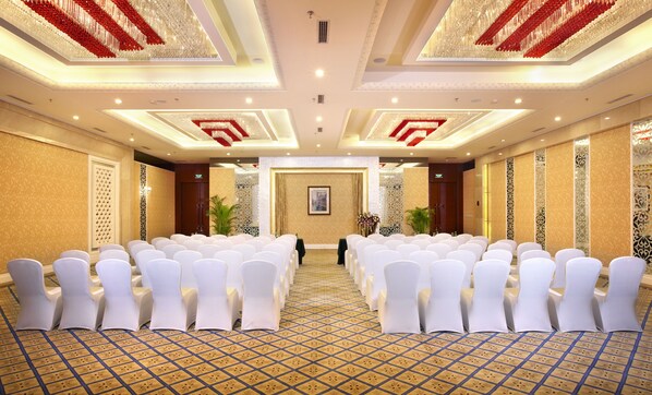 A conference room with rows of white chairs, a patterned carpet, and decorative ceiling lights. - Country Garden Phoenix Hotels Shenyang Yuhong (Shenyang)
