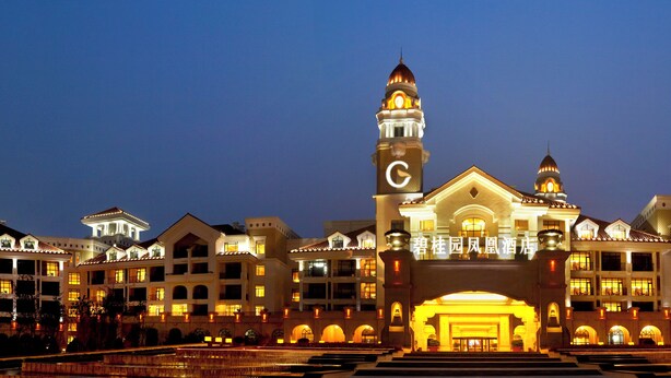 Un hotel grande de varios pisos, con una imponente torre de reloj y una entrada majestuosa.