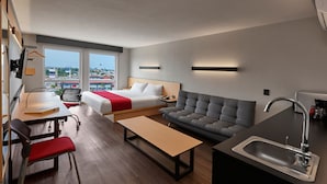 A modern hotel room with a bed, sofa, dining table, and kitchenette. - City Express by Marriott San Luis Potosi Zona Universitaria (San Luis Potosi)