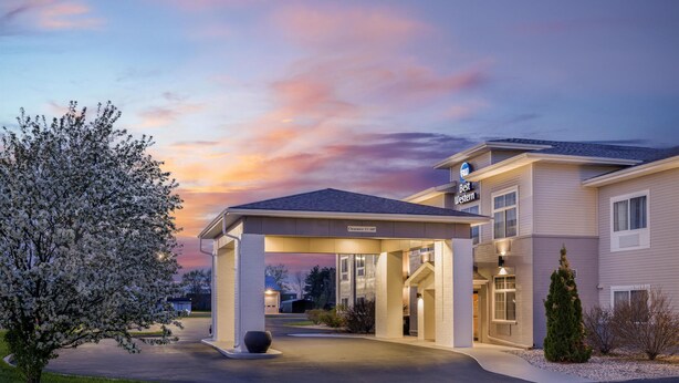A hotel entrance with a covered driveway, a sign indicating 'Best Value,' and a clear sky. - Best Western Plover-Stevens Point Hotel & Conference Center (Plover)
