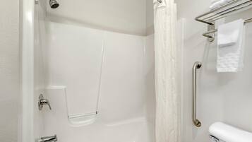 A modern bathroom with a shower, a toilet, and a towel rack.