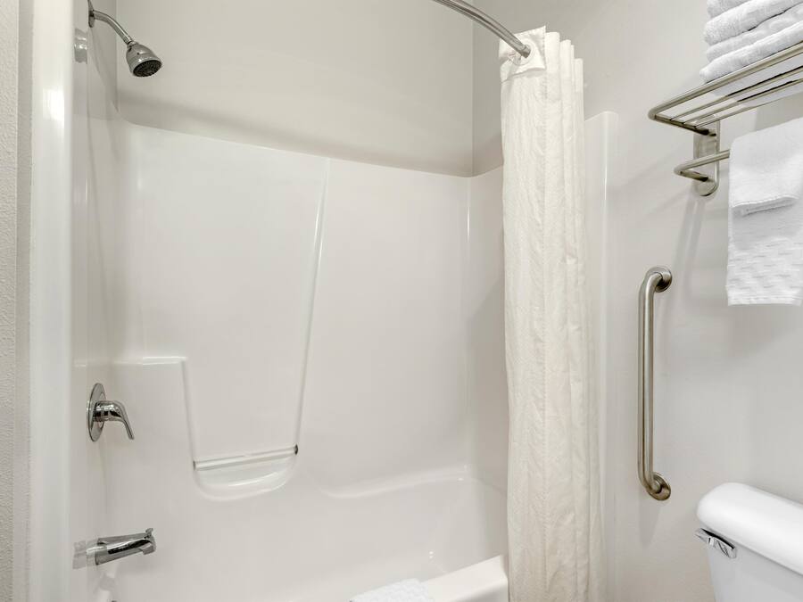 A modern bathroom with a shower, a toilet, and a towel rack.