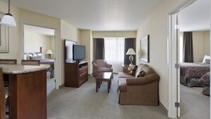Een hotelkamer met een bed, een bank, een televisie, een bureau en een stoel.
