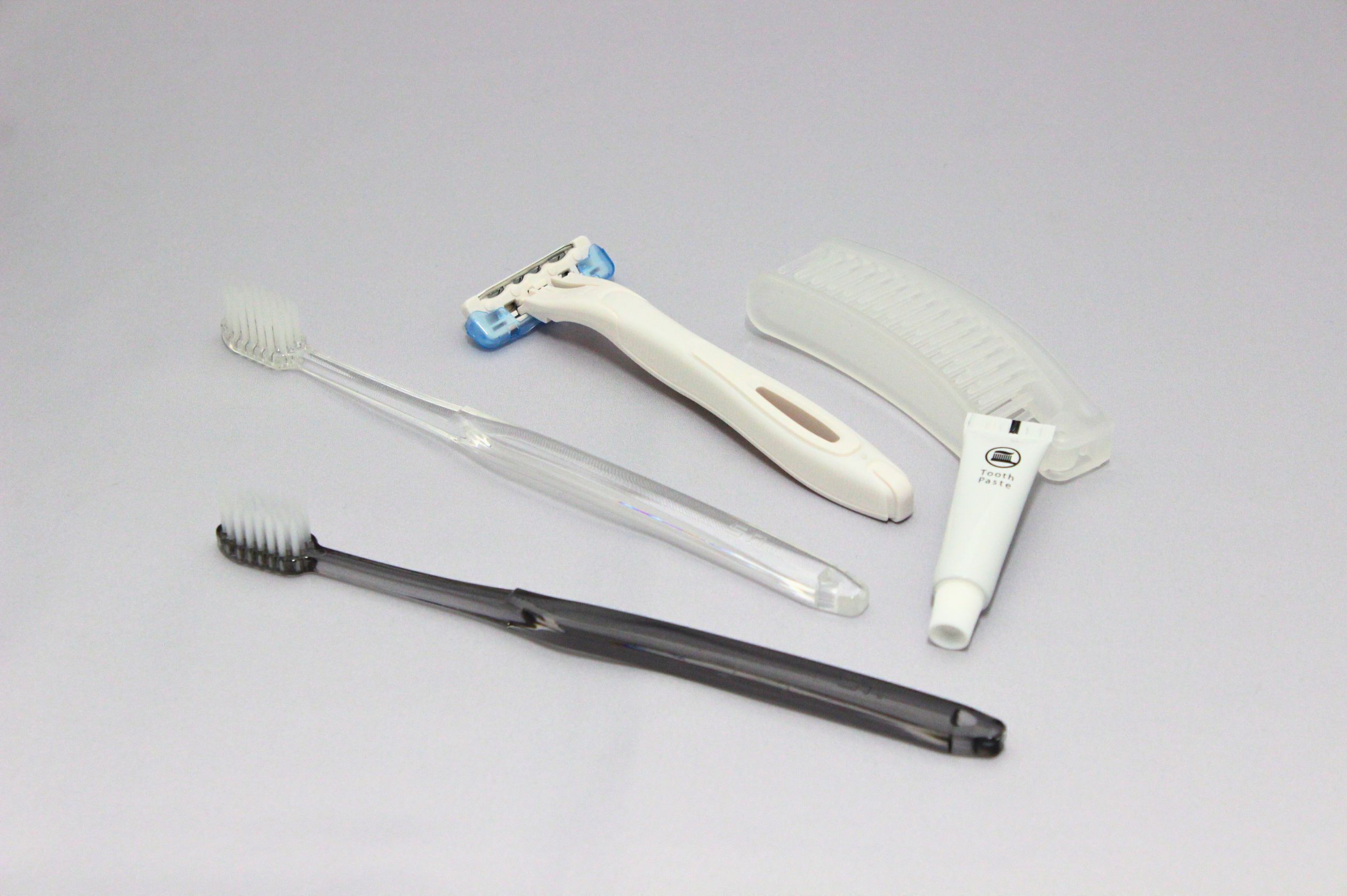 Quatre instruments d’hygiène bucco-dentaire : une brosse à dents, du fil dentaire, un détartreur et un miroir dentaire.