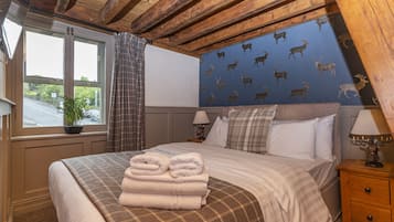 A bedroom with a bed, a nightstand, a lamp, a window with curtains, and a wall with animal decals.
