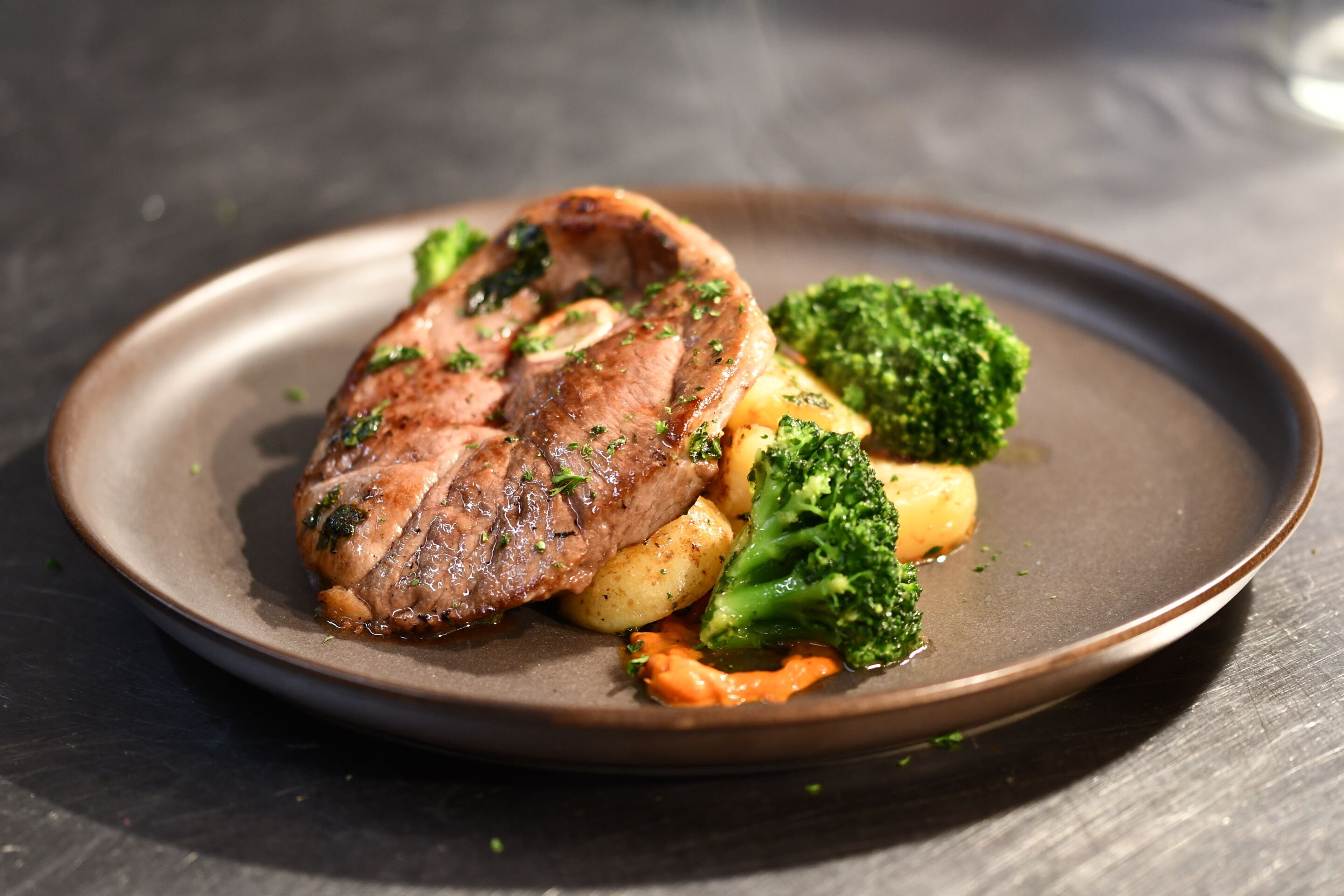 Une assiette contenant un morceau de viande, des pommes de terre et des brocolis.