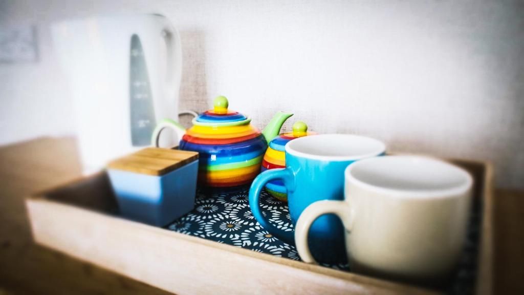 A wooden tray with a teapot, a mug, and a box.
