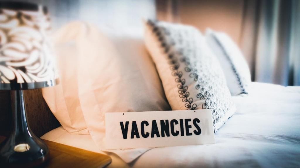 A bed with a sign that reads 'VACANCIES' on it.
