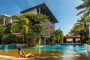 Una piscina al aire libre, sombrillas