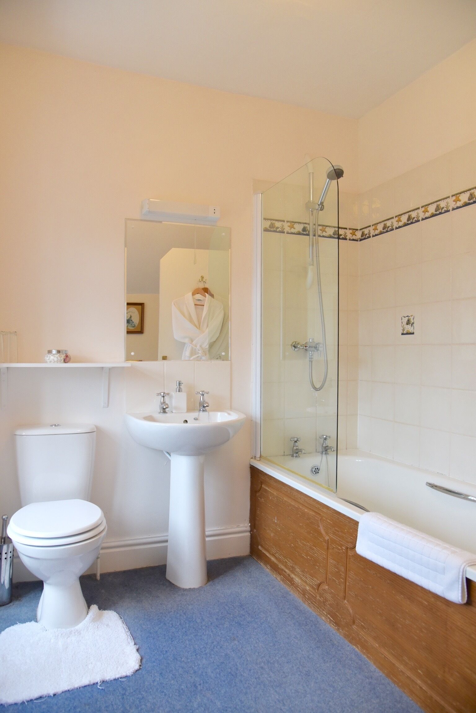 A bathroom with a toilet, sink, and glass-enclosed shower.
