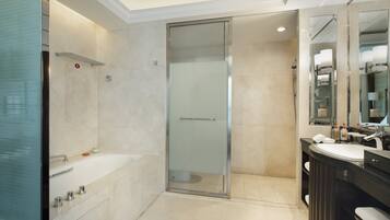 Uma casa de banho moderna com cabine de duche em vidro, uma banheira independente e uma toucador com espelho.