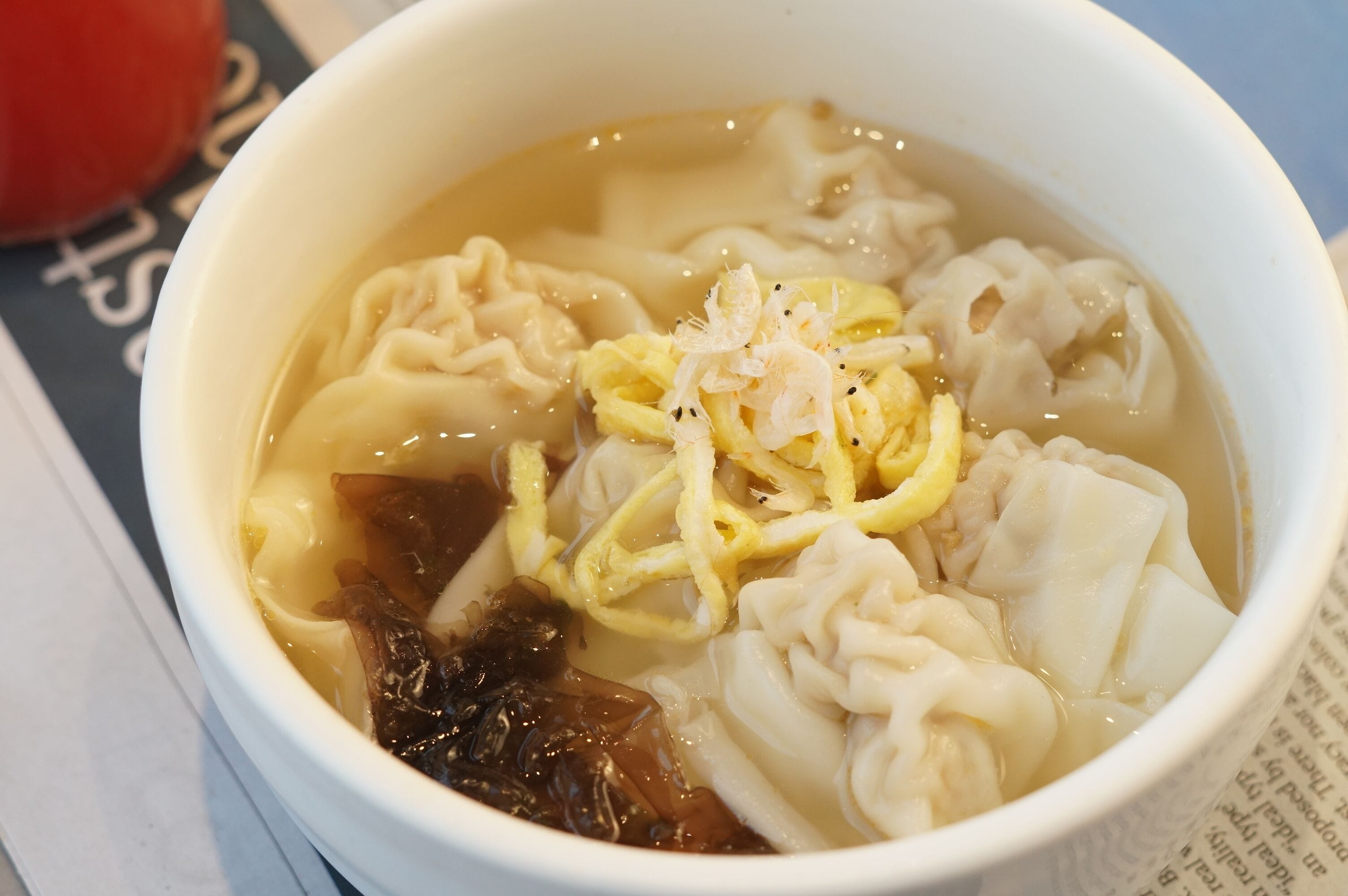 Un tazón de sopa con albóndigas y algas marinas.