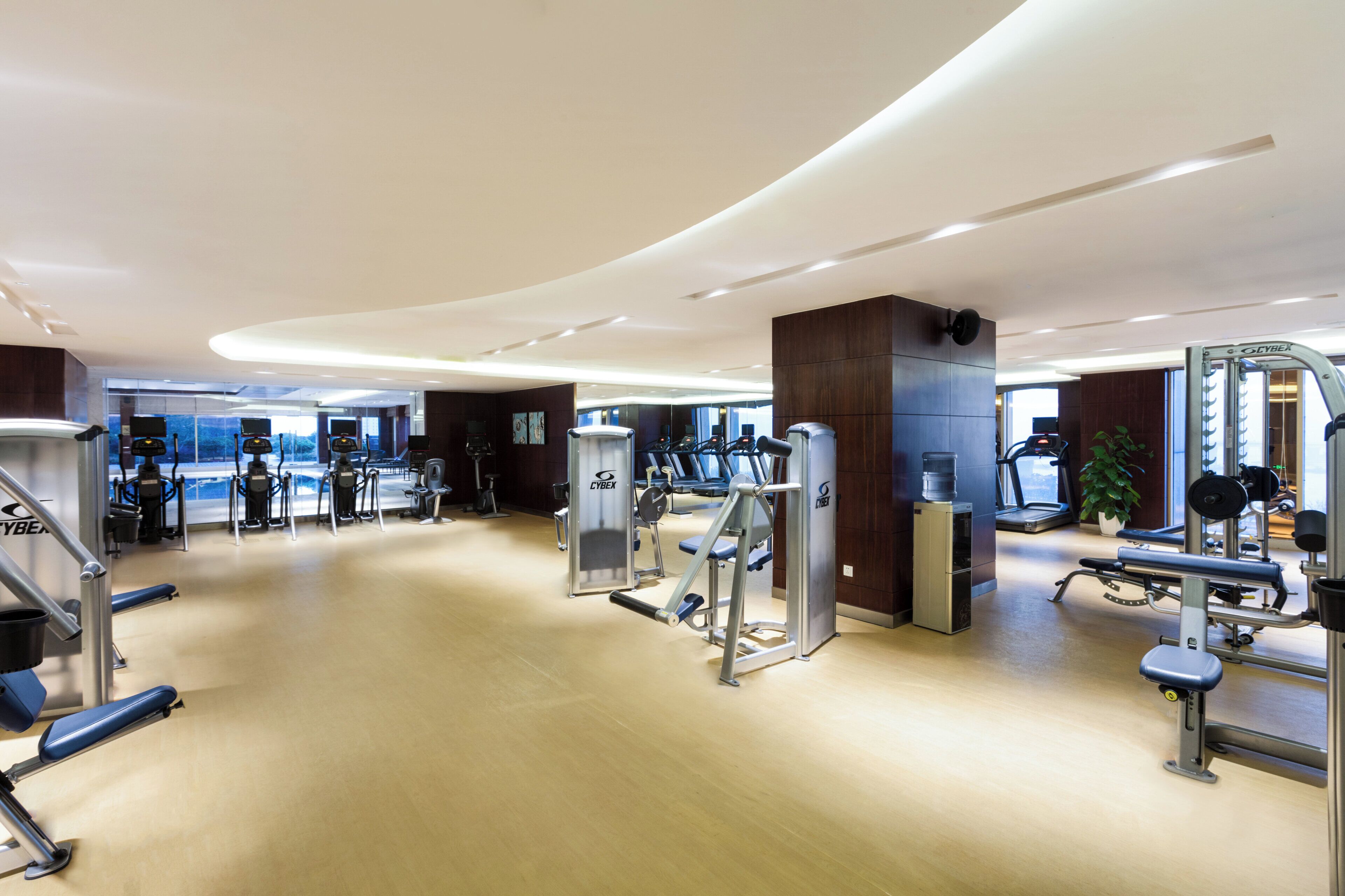 A modern gym with cardio machines, free weights, and a variety of exercise equipment.