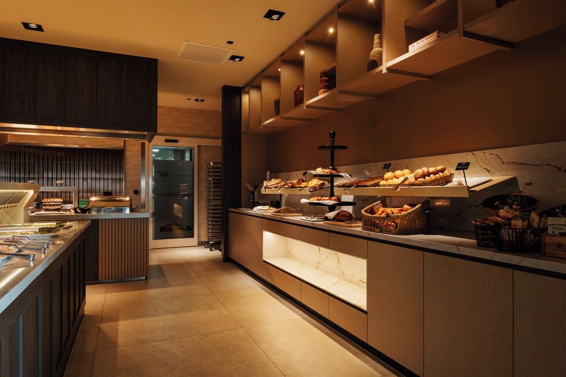 A buffet area with a variety of food items and a modern kitchen in the background.