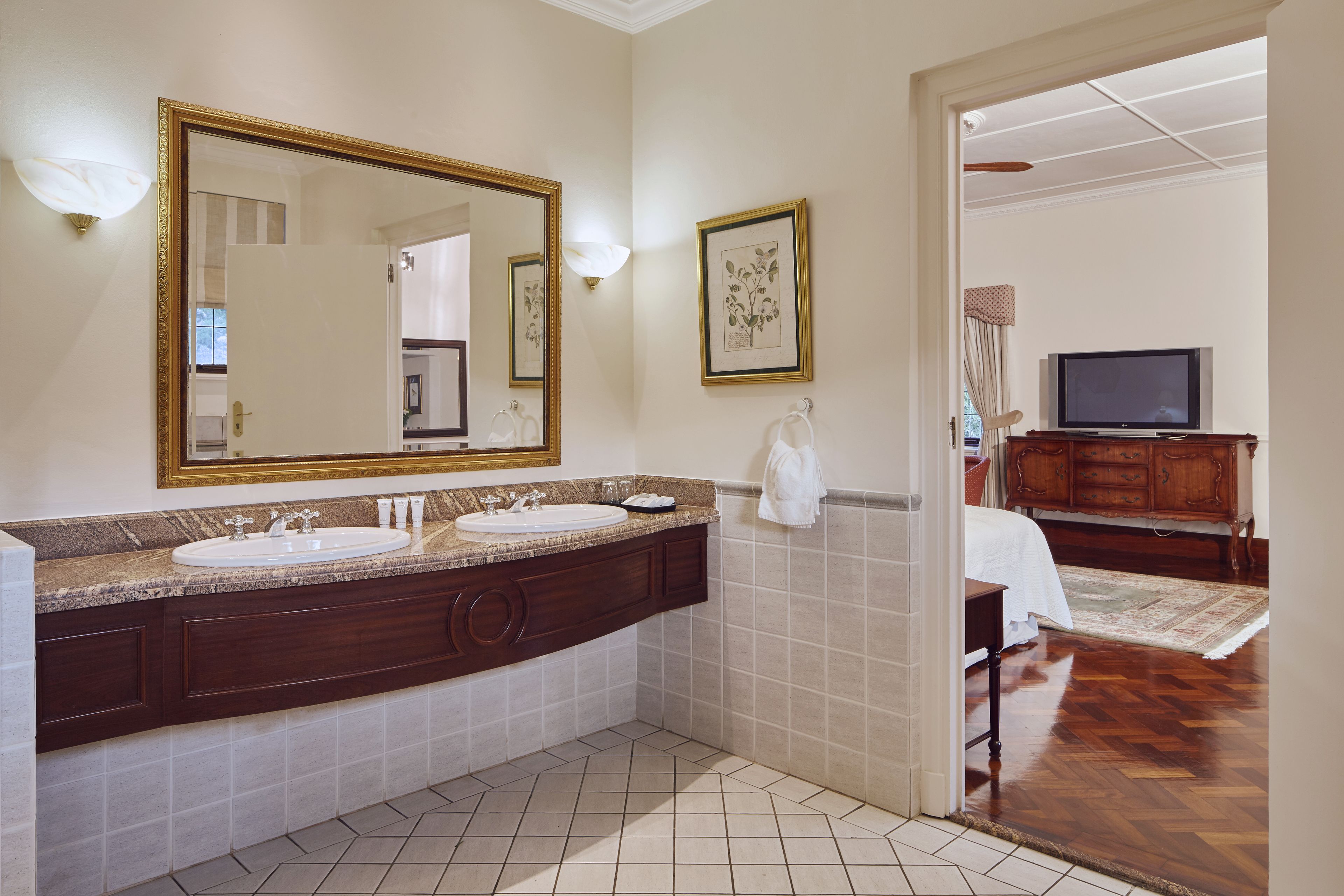 A bathroom with two sinks, a large mirror, and a vanity with dark wood cabinets.