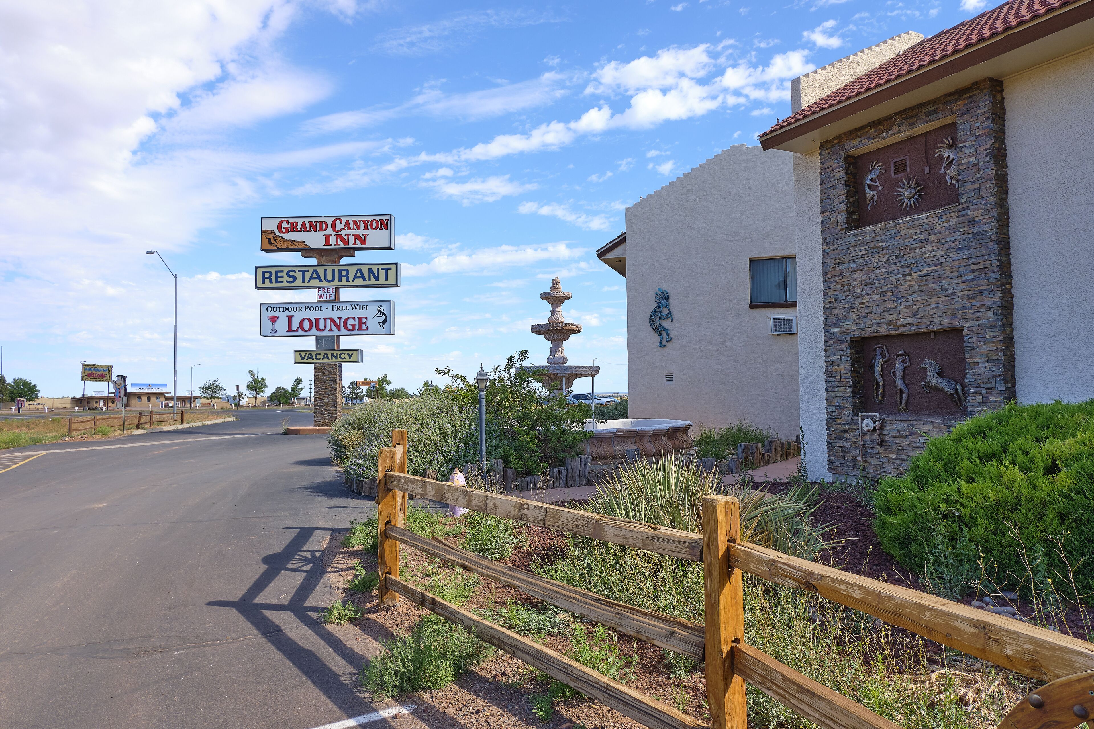 A Grand Canyon Inn sign with amenities including a restaurant, outdoor pool, and lounge.
