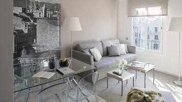 Un salon moderne avec un canapé, une table basse et une table à manger en verre.