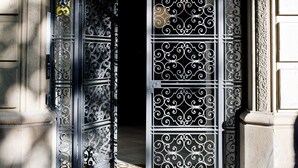 La entrada a Eric Vökel Gran Via Suites, con puertas de metal ornamentadas y un cartel sobre la puerta.