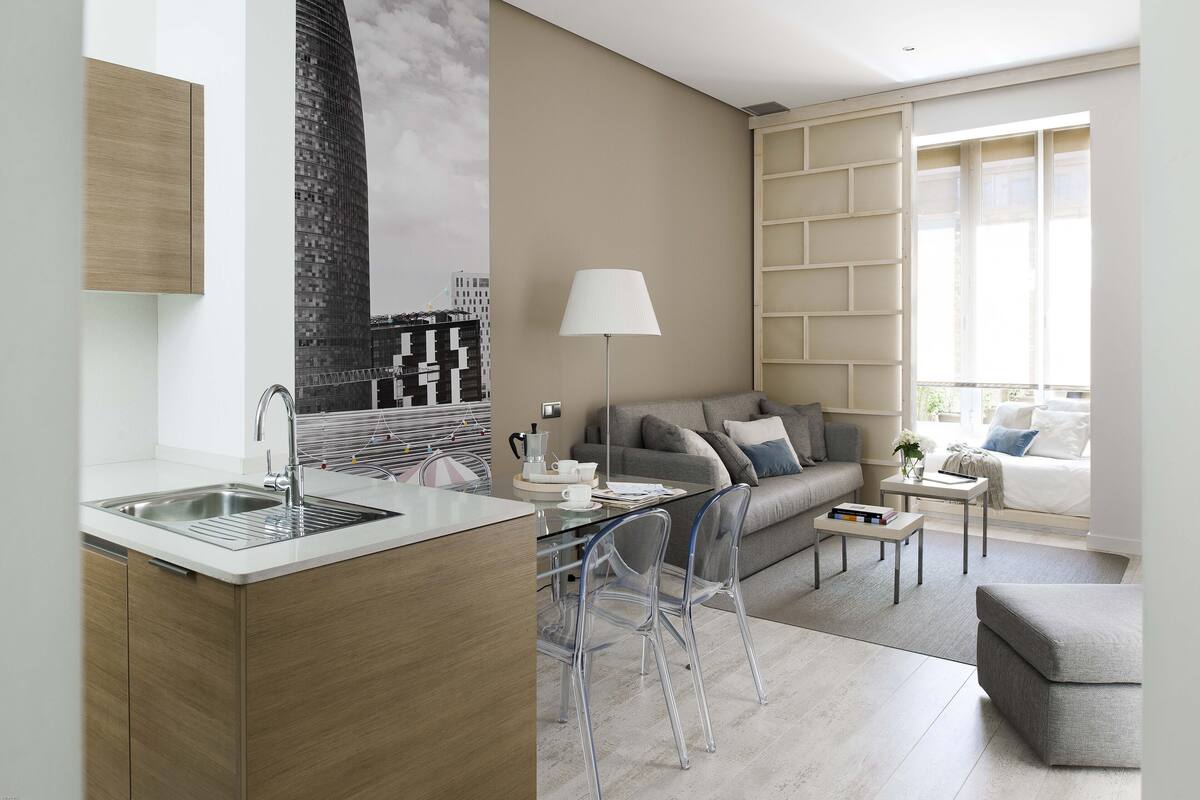Una cocina moderna con un lavamanos integrado y una zona de comedor con una mesa y sillas.