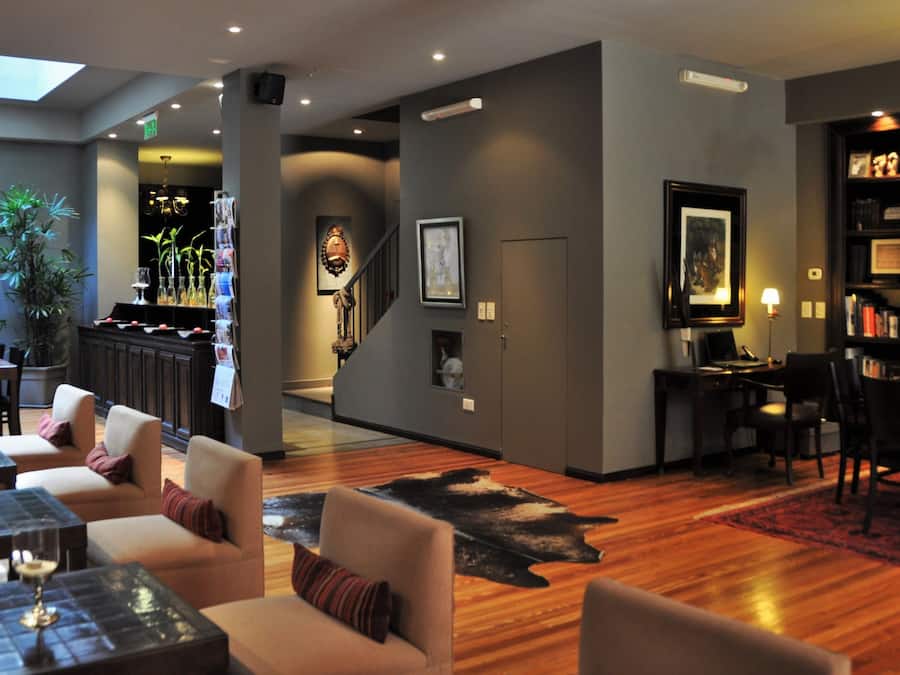 Un moderno vestíbulo de hotel con una zona de bar, asientos y una estantería.