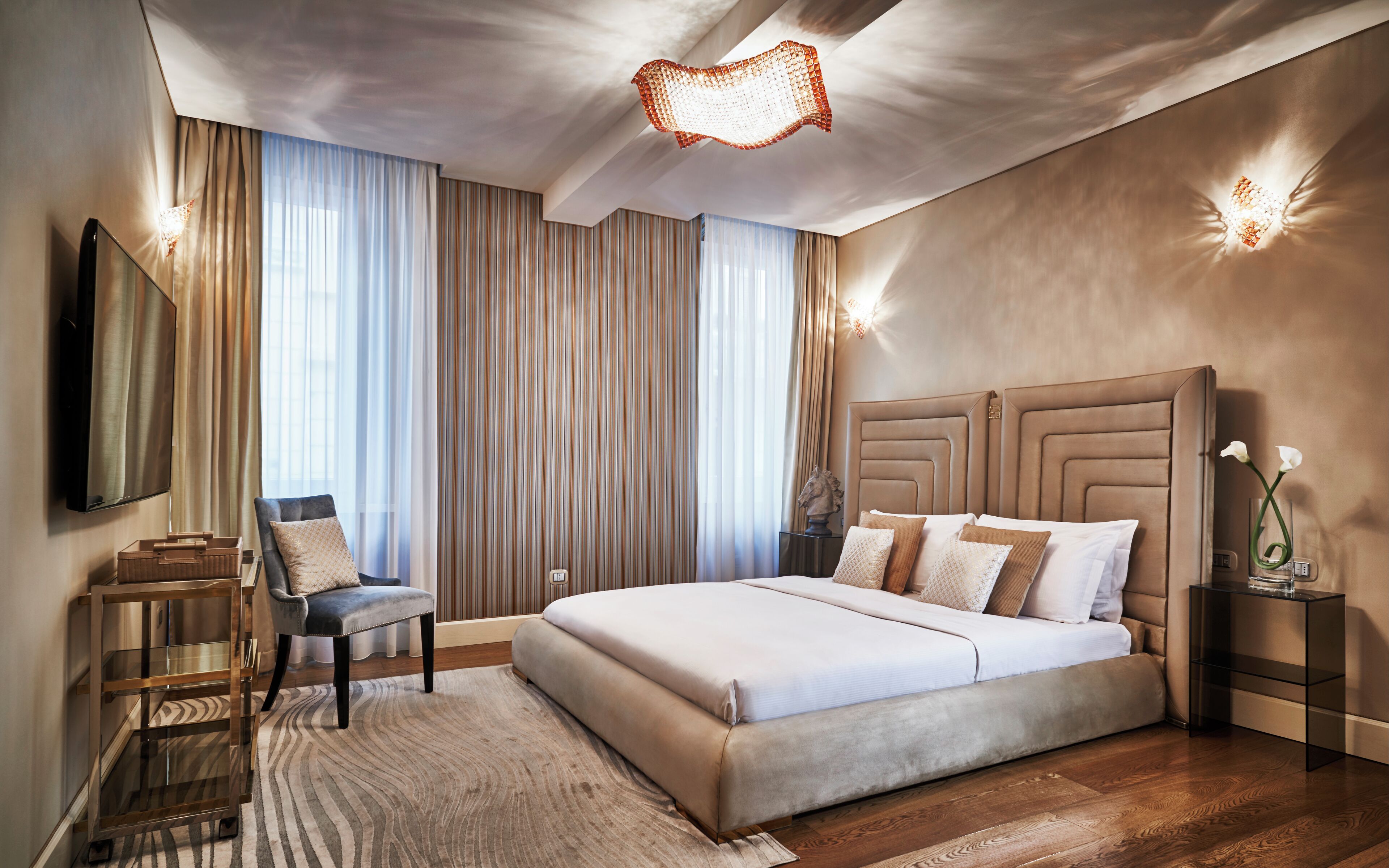 Une chambre à coucher moderne avec un grand lit, un bureau et une chaise.