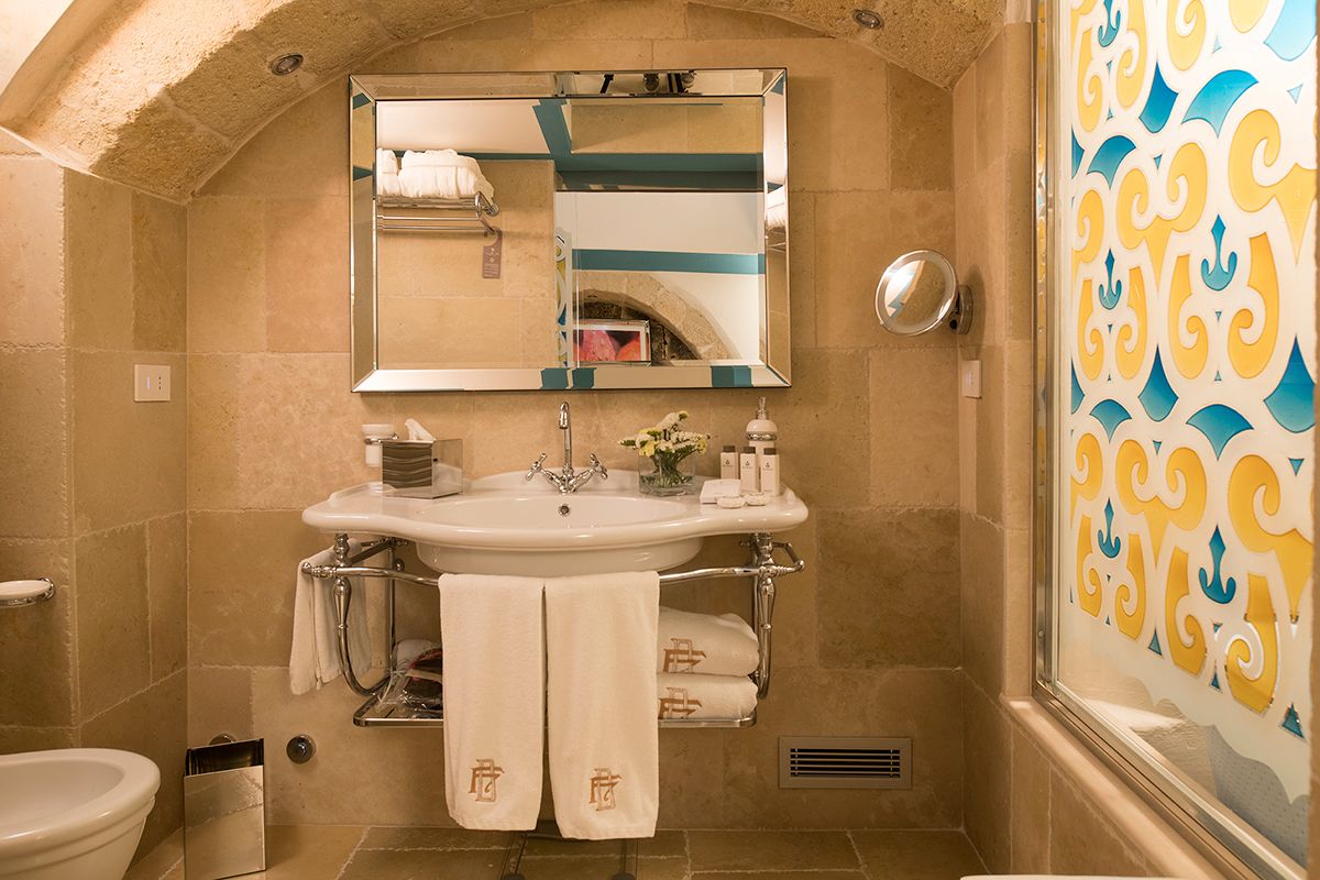 Un baño con un lavabo blanco, un espejo y un perchero para toallas.